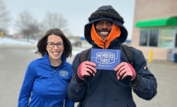 M1 team member gives a gift card to a community member.